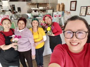 Rotchana Sussman and her mother and the staff in front of the counter at White Springs Cafe.
