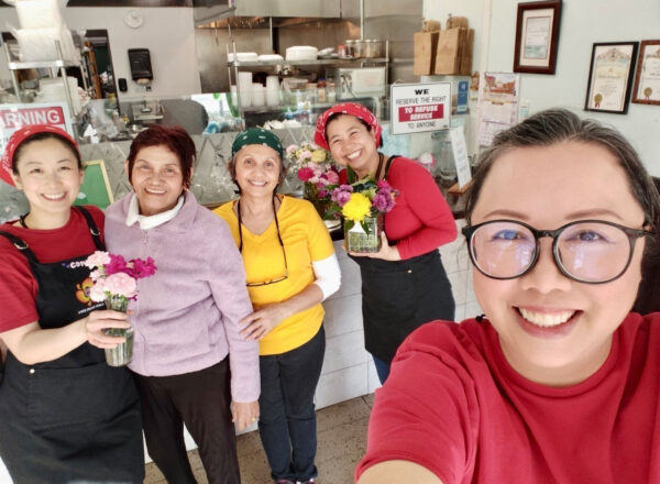 Rotchana Sussman and her mother and the staff in front of the counter at White Springs Cafe.