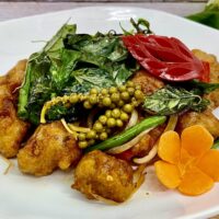 fried nuggets topped with basil on a plate