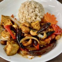 cashew nuts and tofu on a plate with rice
