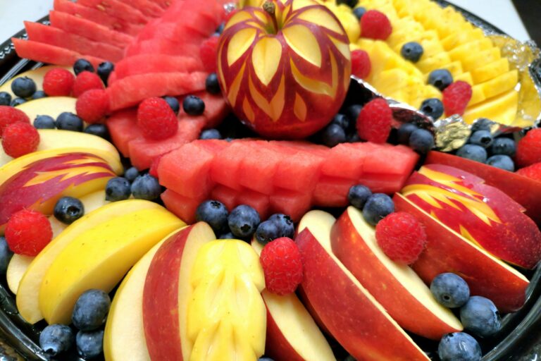 various cut fruits on a round black platter