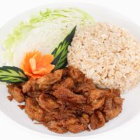 rice and chicken with raw cabbage on a plate