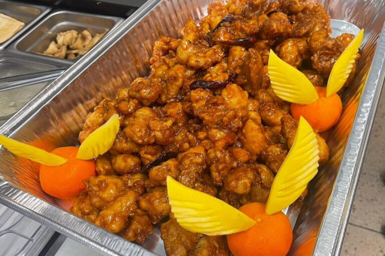 orange chicken nuggets in a large aluminum tray