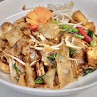flat rice noodles with tofu on a plate