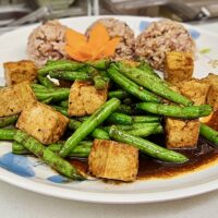 tofu and green beans with rice on a plate