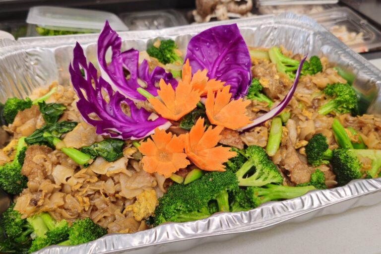 large aluminum tray of cooked rice noodles