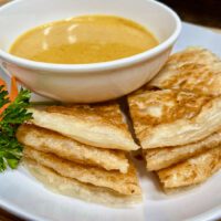 fried roti with a bowl of yellow curry