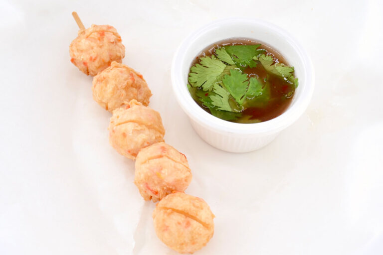Vegan shrimp skewer appetizers on a plate with sauce.