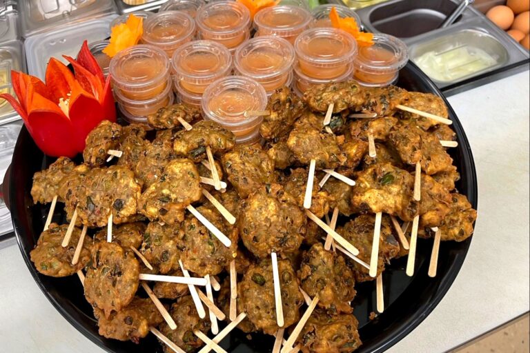 round vegetable patties and packaged sauce on a round black tray